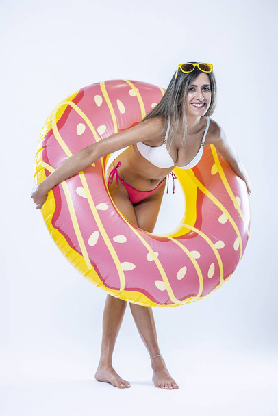 Femme en bikini avec grand anneau de natation gonflable sur un fond gris. - Photo, image