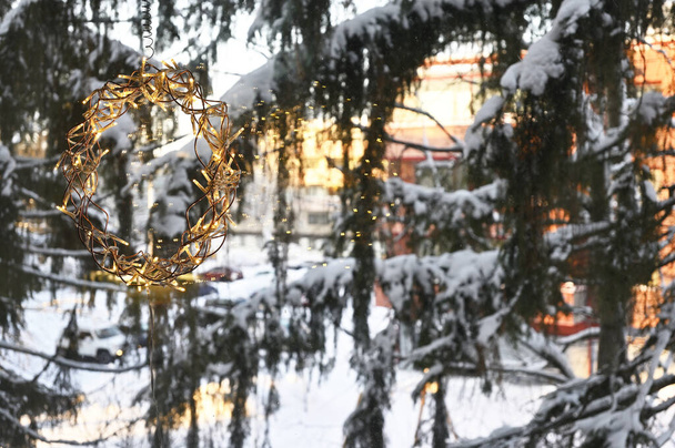 Weihnachtsgirlanden am Fenster und schneebedeckte Tannen vor dem Fenster - Foto, Bild