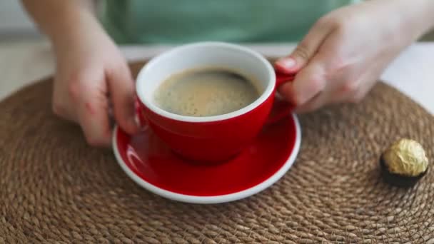 Close up de mulher caucasiana sentado ao lado da janela beber café latte na cozinha. Mulher bonita gosta de beber café no café.  - Filmagem, Vídeo