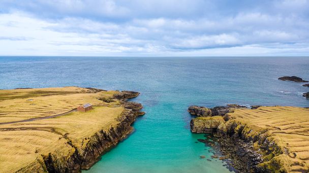 Aerial drone view of Port of Stoth on the Isle of Lewis. Turquoise water surrounded by outcrops and cliffs of surrounding cove in Outer Hebrides - Photo, Image