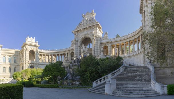 Il Palais Longchamp di Marsiglia si erge in uno splendore maestoso, con i suoi intricati archi in pietra e la grande scalinata che si crogiola nella morbida luce del giorno. Statue e fontane adornano questo monumento della storia, immerso in un parco lussureggiante, trasudando l'eleganza di  - Foto, immagini