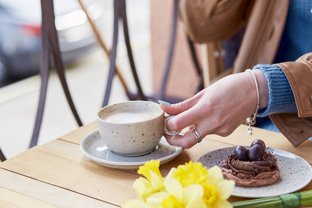 Spring time Snack - relaksujący moment przy kawie i deserze wśród świeżych żonkili. - Zdjęcie, obraz