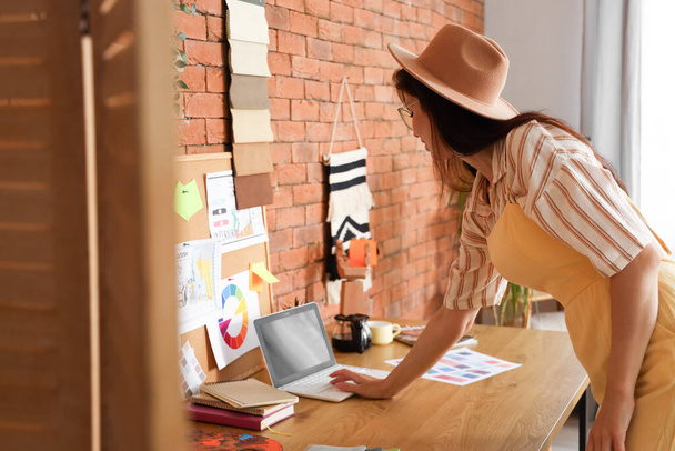 Designer de interiores feminino trabalhando com laptop no escritório - Foto, Imagem