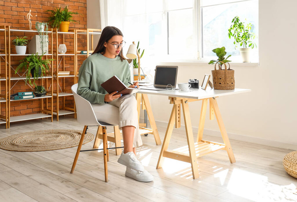 Mladá žena psaní v notebooku na domácí kanceláři - Fotografie, Obrázek