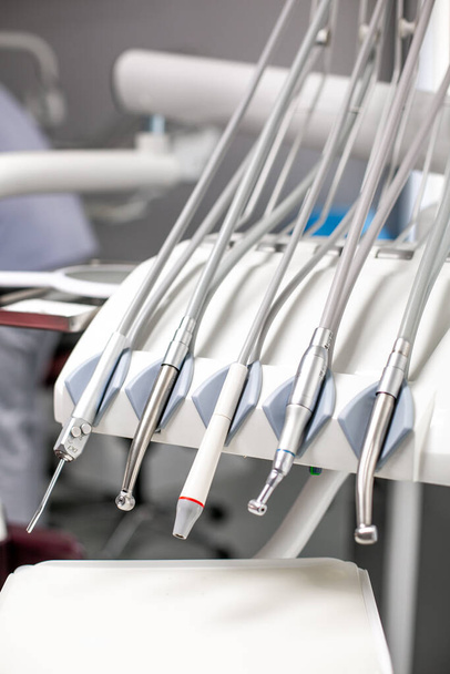 ferramentas de dentista e queimadores em uma cadeira de dentista na Clínica Dentista. Diferentes instrumentos e ferramentas dentárias em um consultório de dentistas. dentista e equipamentos odontológicos em hospital - Foto, Imagem