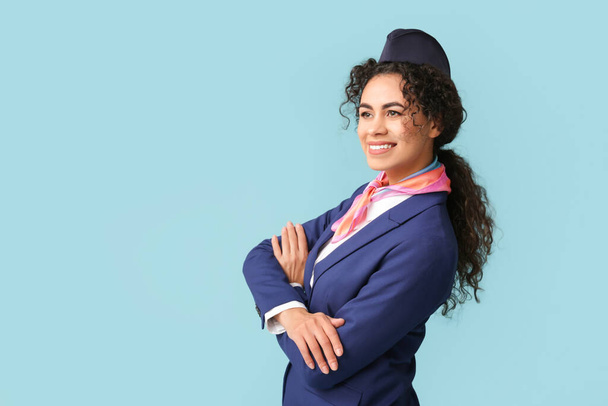 Gyönyörű afro-amerikai stewardess kék háttérrel - Fotó, kép