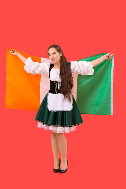 Jovem com bandeira da Irlanda em fundo vermelho. Celebração do Dia de São Patrício - Foto, Imagem