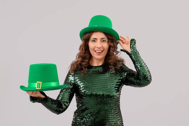 Женщина в зеленой одежде и в шляпе на светлом фоне. Празднование Дня Святого Патрика - Фото, изображение