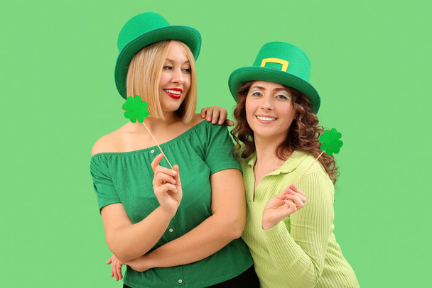 Счастливые женщины с клеверами на зеленом фоне. День Святого Патрика - Фото, изображение