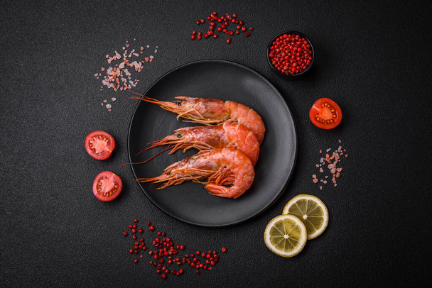 Tiger shrimp or langoustine boiled with spices and salt on a dark concrete background - Photo, Image