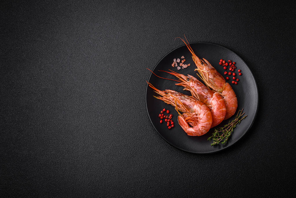 Camarones tigre o langostino cocidos con especias y sal sobre un fondo de hormigón oscuro - Foto, Imagen