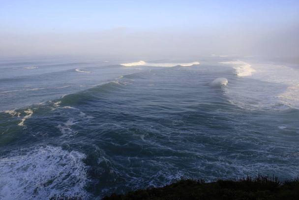 ポルトガルのOeste地域のナザレ灯台の北海岸からの波を見る - 写真・画像
