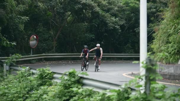 joven asiático pareja ciclistas a caballo bicicleta en rural camino - Metraje, vídeo