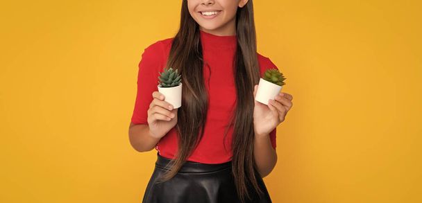 smiling girl with cactus in pot on yellow background. - Фото, зображення
