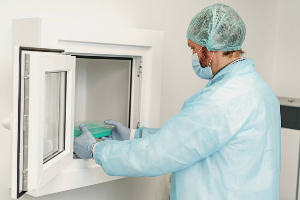 Mužský vědec v uniformě drží zkumavky v laboratoři. Medicína a výzkum v chemii - Fotografie, Obrázek