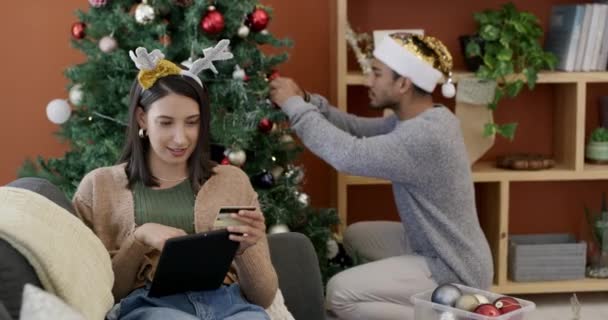 Tablet, online shopping and couple at Christmas in home with discount on gift and holiday decoration. People, celebrate and save on ecommerce app with festive sales on present or pay with credit card. - Footage, Video