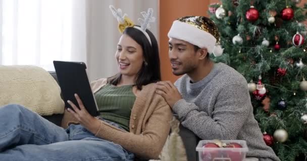 Tablet, online ψώνια και ζευγάρι τα Χριστούγεννα στο σπίτι με την αγορά του δώρου και συζήτηση των διακοπών. Ευτυχία, οι άνθρωποι και να χαλαρώσετε με τα μέσα κοινωνικής δικτύωσης, app ή μιλάμε για πωλήσεις ηλεκτρονικού εμπορίου και έκπτωση. - Πλάνα, βίντεο