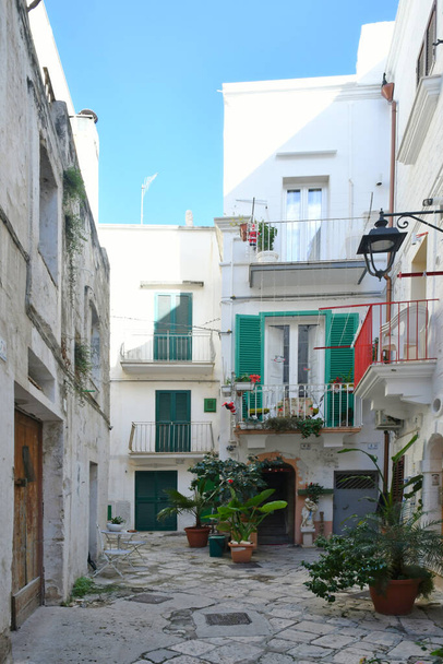 Kapea katu keskuudessa vanhoja taloja Monopoli, kaupunki maakunnassa Bari, Italia. - Valokuva, kuva