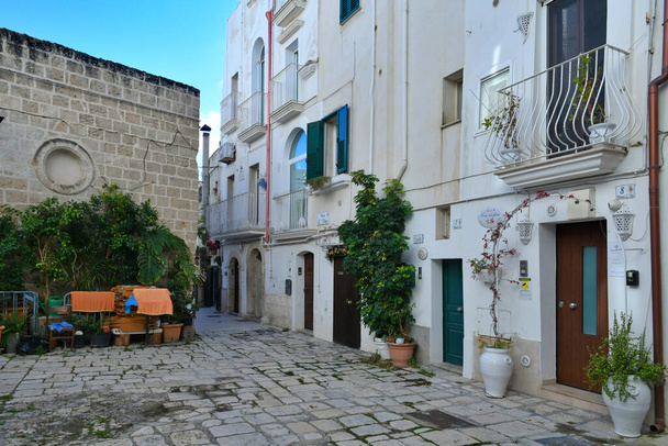 Узкая улица среди старых домов Монополи, город в провинции Бари, Италия. - Фото, изображение