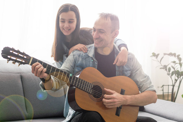 Художньо талановита дівчина, яка показує вчительці латинської музики нову пісню, яку вона навчилася грати на акустичній гітарі вдома. Високоякісна фотографія - Фото, зображення