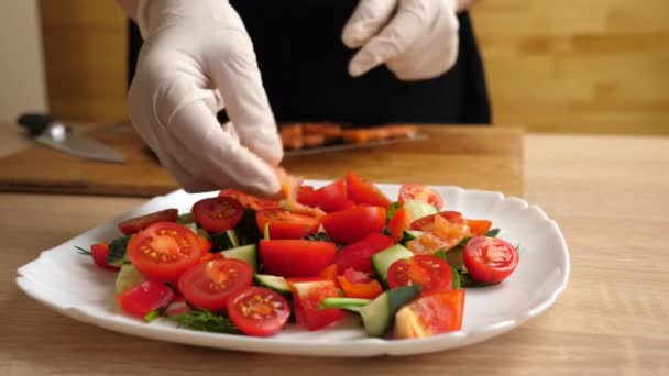Se añaden trozos de salmón a una ensalada de verduras. Preparación de ensalada de verduras - Metraje, vídeo
