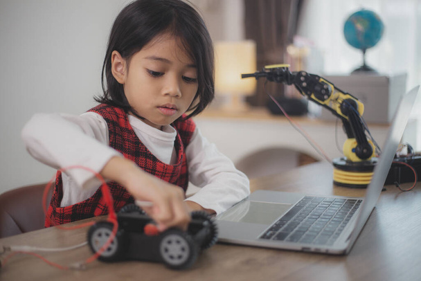 Концепция образования STEM. Азиатские студенты учатся дома, кодируя руки роботов в STEM, математика инженерных наук компьютерный код в робототехнике для детских концепций. - Фото, изображение