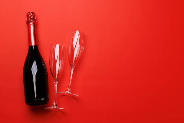 Бокалы шампанского и бутылка на красном фоне с текстовым пространством. Открытки на день Святого Валентина - Фото, изображение