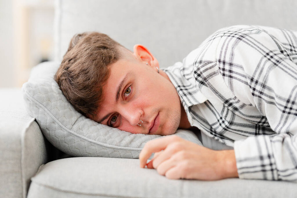 Triste jeune homme allongé sur le canapé. Concept de dépression et de solitude. - Photo, image
