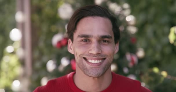 Christmas, face and a happy man in home for celebration of party event by tree. Portrait, smile and person at garden for xmas outdoor in backyard on holiday, festive season and new year in Brazil. - Footage, Video