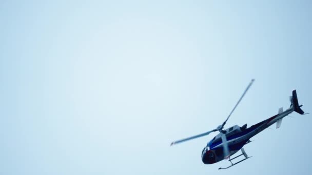 Helikopter vliegt in de blauwe lucht - Video