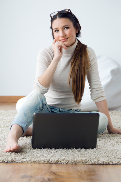 Beautiful young woman working on her laptop at home. - Photo, Image
