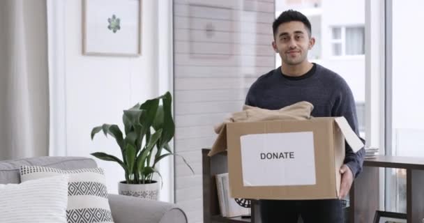 Man, face and donation in home, charity box and kindness with happy giving to ngo organisation. Volunteer, pride or smile portrait by clothing, cardboard or service to community with generosity. - Footage, Video