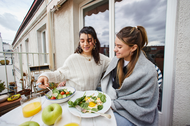 щаслива і молода пара лесбіянок, насолоджуючись здоровим сніданком на балконі вдома, lgbt любов - Фото, зображення