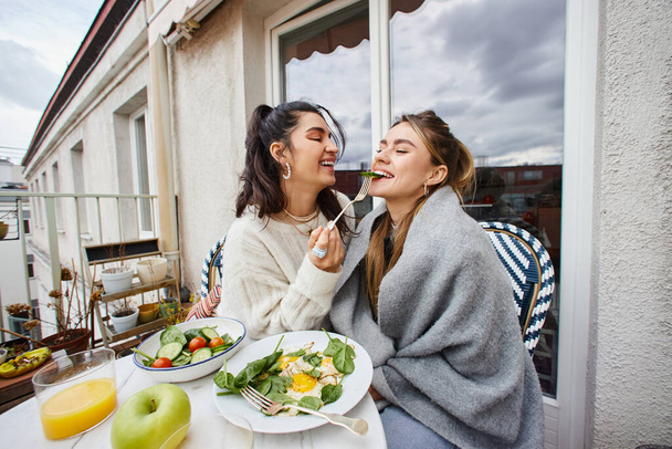 šťastný mladý lesbička žena krmení její přítelkyně při snídani na balkóně, Igbt pár - Fotografie, Obrázek