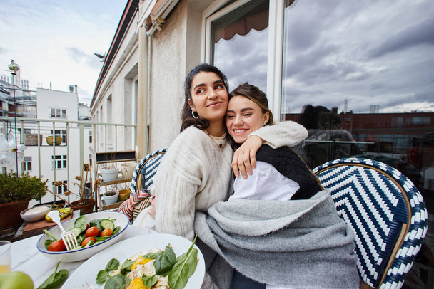 feliz momento de joven lesbiana pareja abrazando mientras desayunando en balcón, lgbt concepto - Foto, Imagen