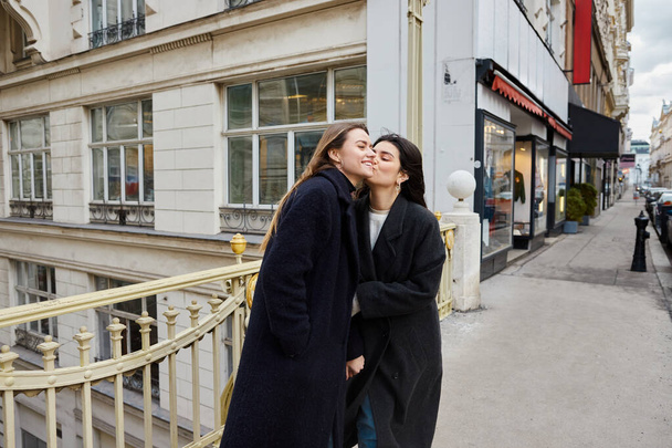 Интимный момент влюбленных лесбиянок, стоящих вместе на улице в европейском городе - Фото, изображение