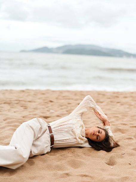 Sérénité embrassée par le soleil : Une jeune femme embrassant la solitude bénie sur une plage tropicale captivante - Photo, image