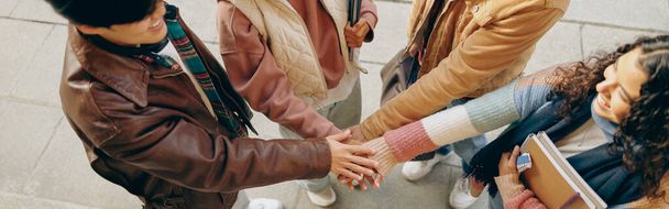 Top näkymä nuorten opiskelijoiden laittaa kätensä yhteen seisoo lähellä kampuksen rakennus - Valokuva, kuva