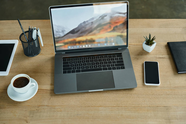 Egy elegáns nyitott laptop számítógép egy rusztikus fa asztal tetején pihen, egyensúlyt teremtve a digitális és a természetes elemek között egy modern irodában.. - Fotó, kép