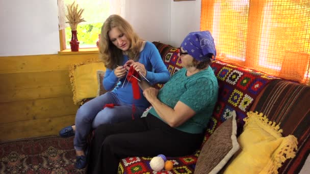 Starší žena učí vnučka dívky, jak háčkovat - Záběry, video