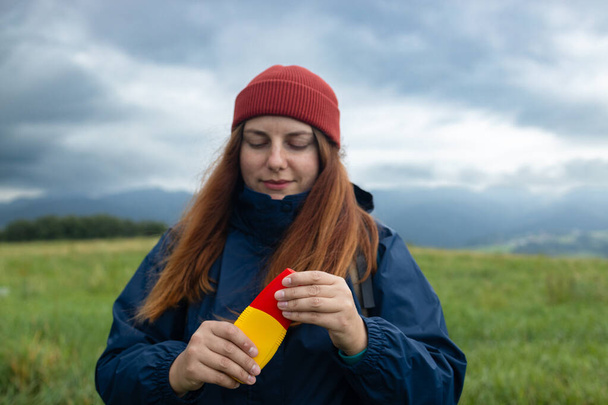 ハイキング旅行で屋外で蚊スプレーを使用する女性. 若い女性バックパッカーの観光客のクローズアップ 手のバグスプレーを適用. 高品質の写真 - 写真・画像