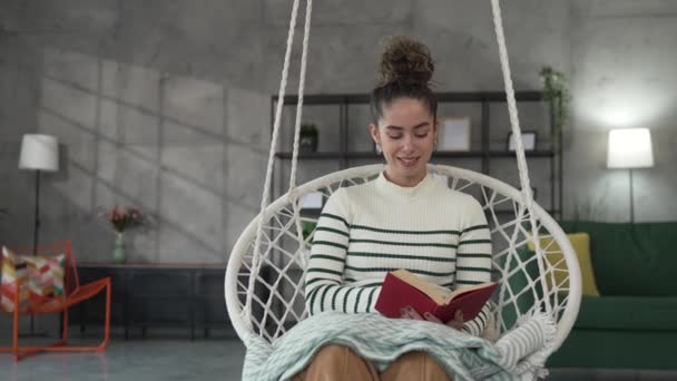 νέα ενήλικη γυναίκα ένα θηλυκό διαβάσει βιβλίο ή μελέτη στο σπίτι - Πλάνα, βίντεο