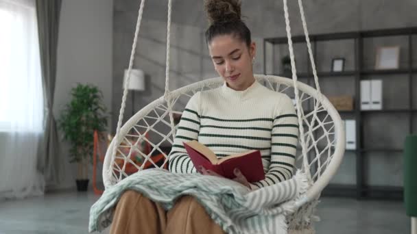 νέα ενήλικη γυναίκα ένα θηλυκό διαβάσει βιβλίο ή μελέτη στο σπίτι - Πλάνα, βίντεο