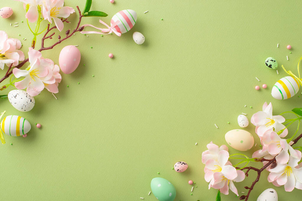 Delícia da primavera: vista superior de ovos animados, flores de maçã e polvilhas de açúcar em um fundo verde pastel. Espaço para o seu texto ou publicidade - Foto, Imagem