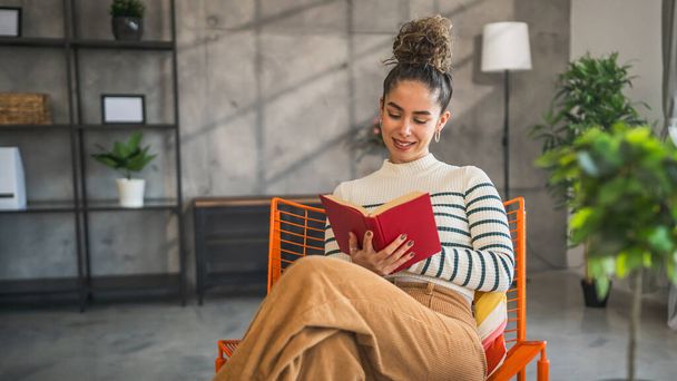 mladá dospělá žena jedna žena číst knihu nebo studovat doma - Fotografie, Obrázek