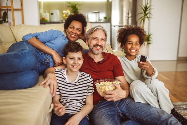 Jong gezin thuis samen Tv kijken en samen plezier. - Foto, afbeelding