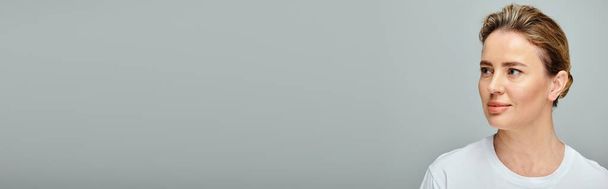 mulher atraente com cabelo loiro e lentes de contato no fundo cinza olhando para longe, banner - Foto, Imagem