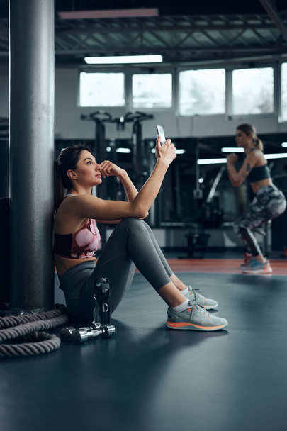 Femme sportive faisant une pause dans une salle de gym après l'exercice. - Photo, image