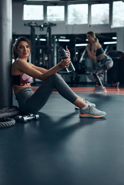 Femme sportive faisant une pause dans une salle de gym après l'exercice. - Photo, image