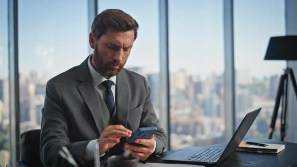 Serious professional using smartphone in modern office. Company leader typing browsing computer working on project online. Confident financial manager messaging in cell. Corporate employee concept. - Footage, Video